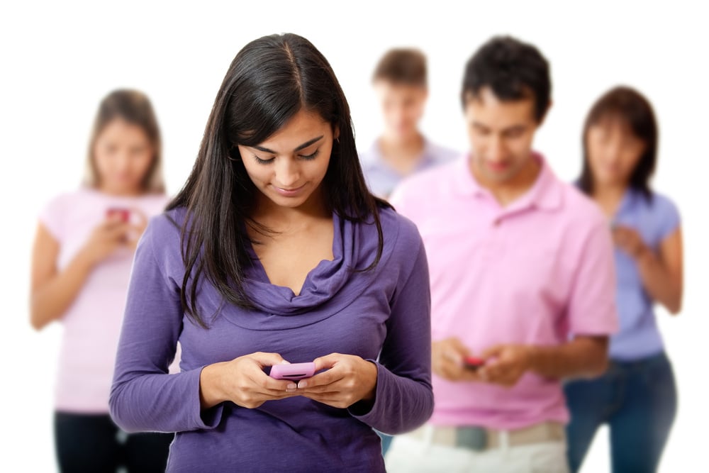 Group of young people texting on their mobile phones